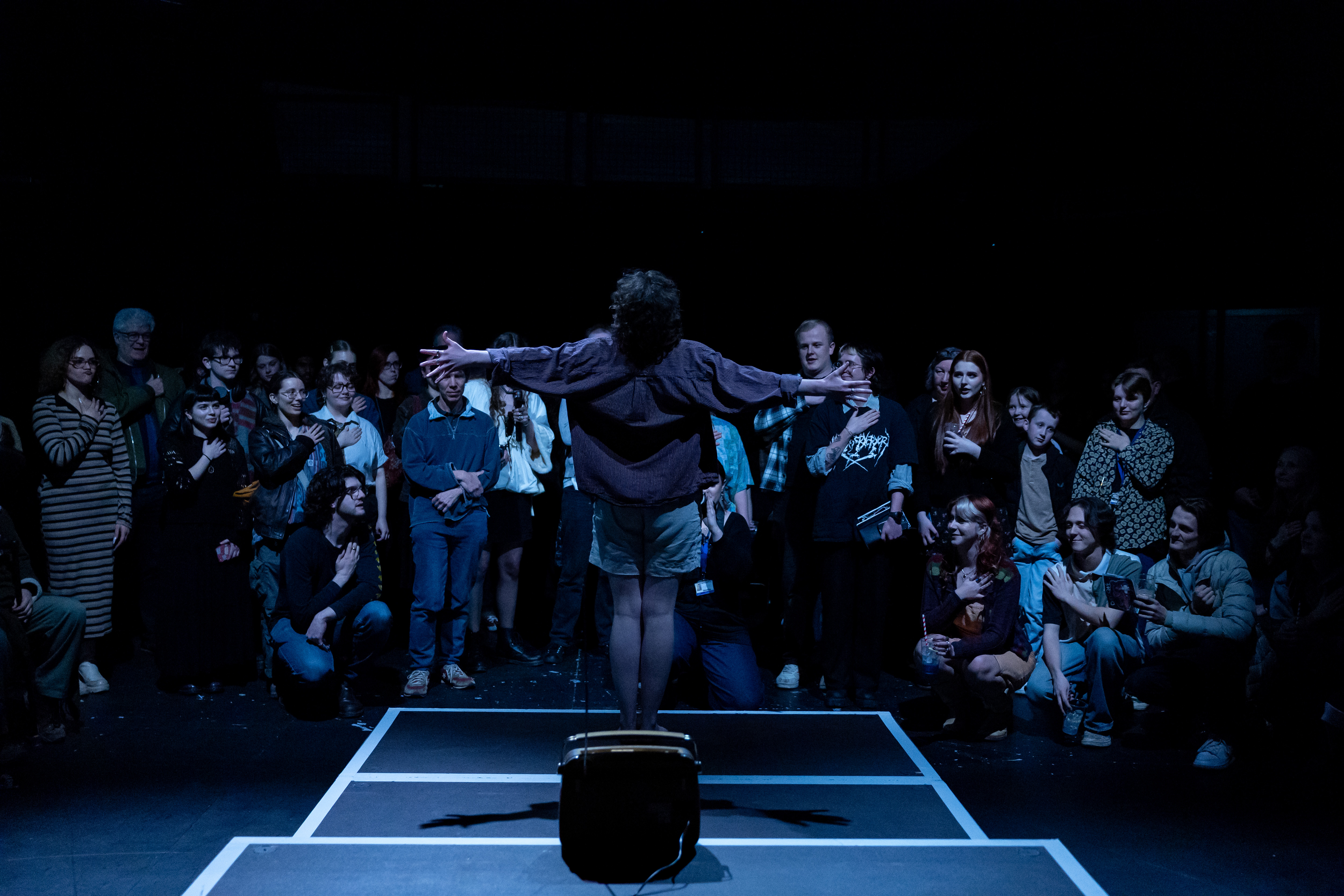 Photo of Soph standing with arms outstretched in Glitter Pirate Radio performance photo taken by Cam Harle 